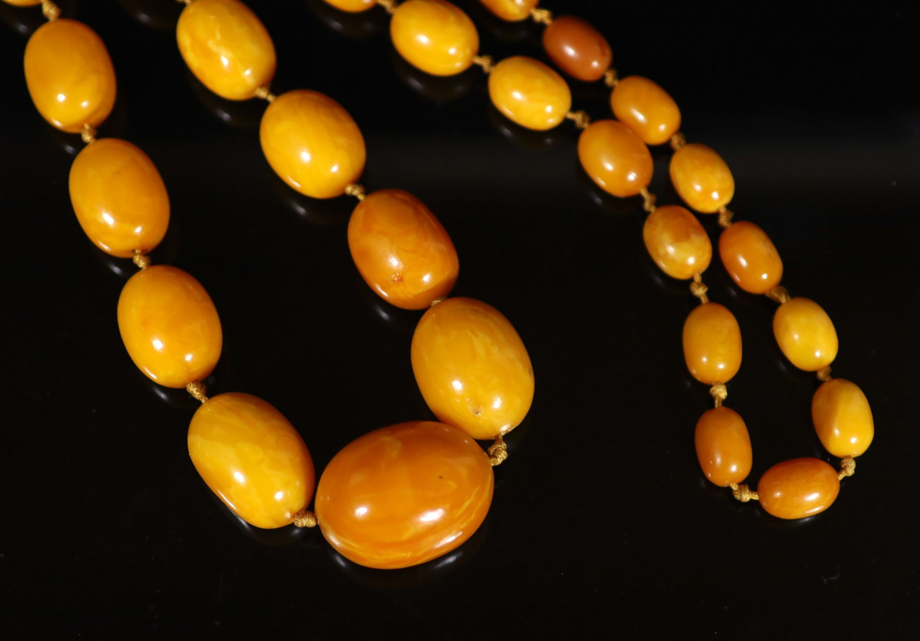 A single strand graduated oval amber bead necklace, 98cm, gross weight 117 grams.